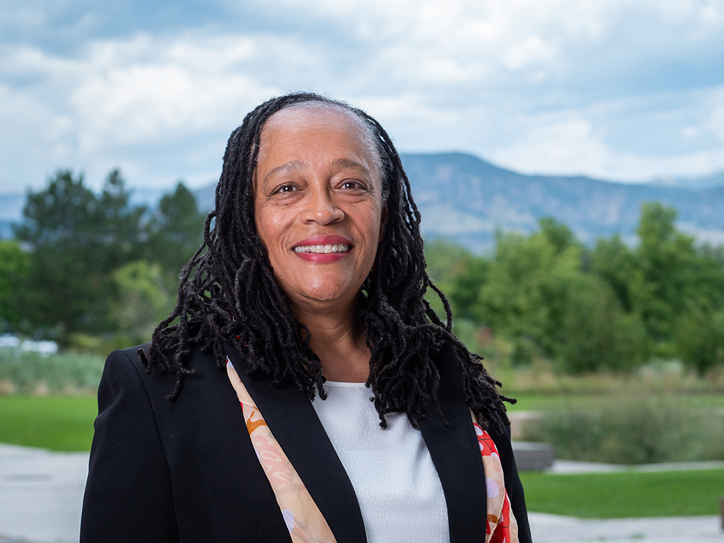 Dr. Tanya Ennis' headshot, where she stands outside with the mountains of Boulder, Colorado in the background.