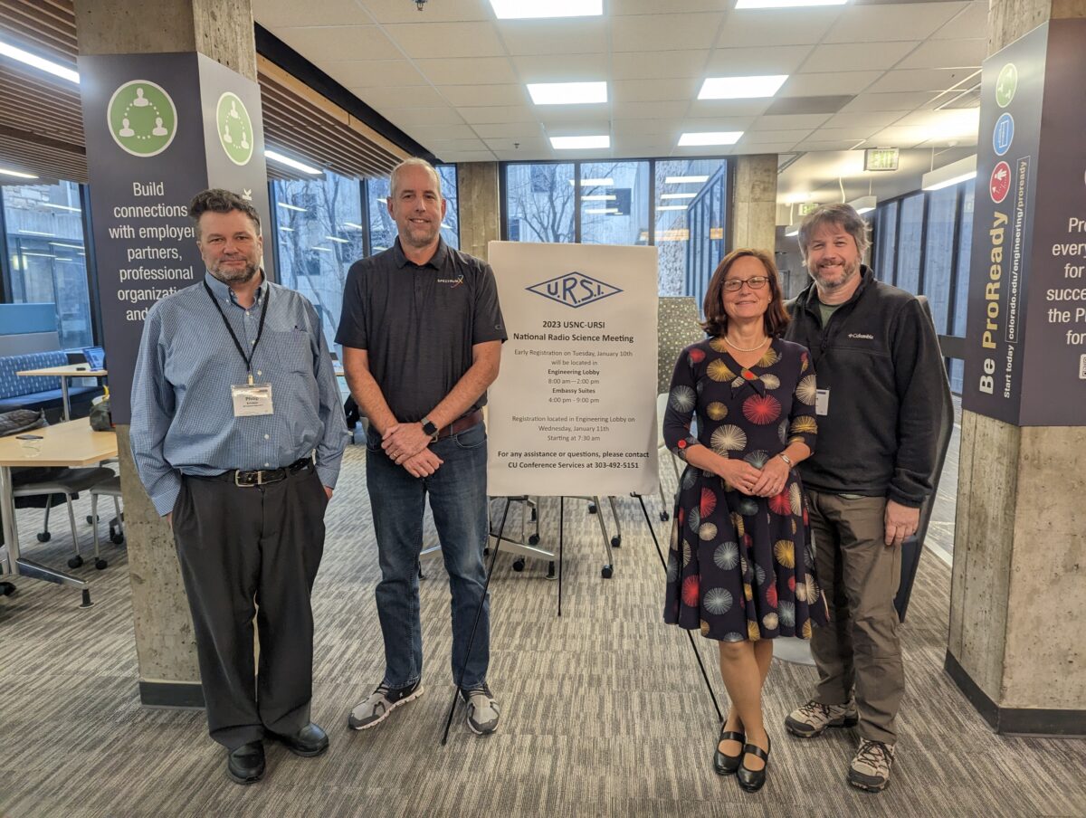 Four of six SpectrumX attendees at the URSI NRSM 2023 event are pictured in front of an event sign. From left are Phil Erickson, SpectrumX Research Partner and Principal Research Scientist at MIT Haystack Observatory; Scott Palo, SpectrumX Associate Director and Professor at the University of Colorado Boulder; Zoya Popovic, SpectrumX Research Partner and Professor at the University of Colorado Boulder; and Bobby Weikle, SpectrumX Steering Committee Chair, Radio and Network Technologies Lead, and Professor at the University of Virginia.