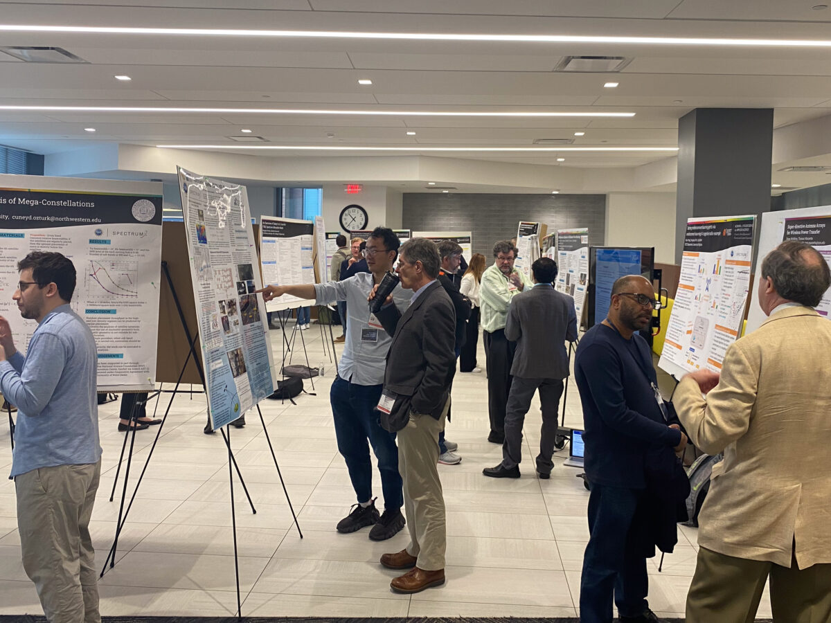 NSF Spectrum Week attendees discuss research during a poster session.