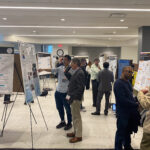 NSF Spectrum Week attendees discuss research during a poster session.