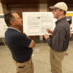 Ryan Murray, AWaRE REU researcher, stands and discusses his research poster at the Student REU Research Symposium. Photo by Wes Evard.